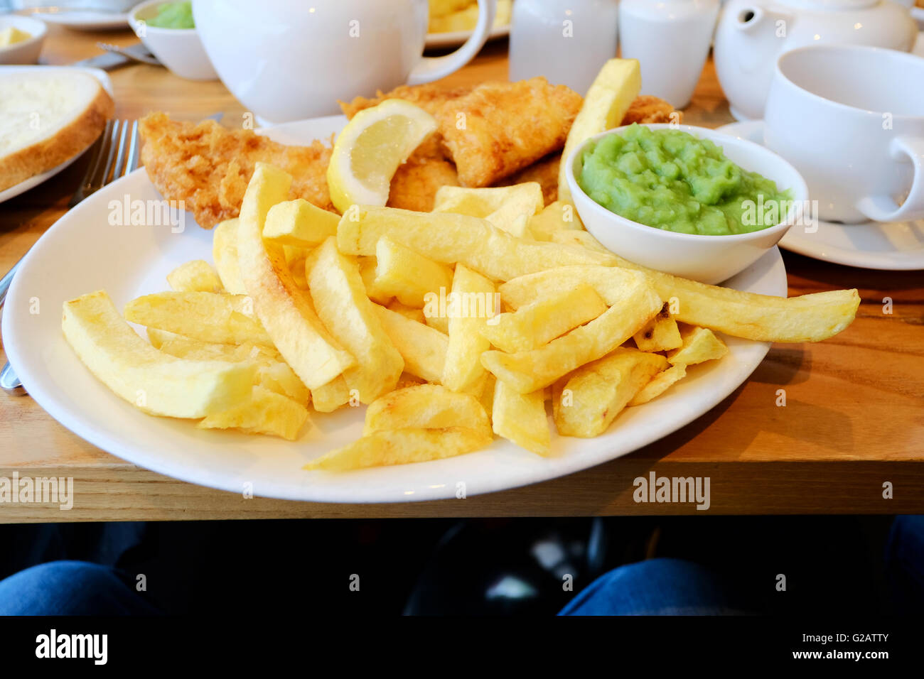 Ein Teller mit englischen Fisch, Chips und Erbsenpüree serviert auf einem Teller in einem restaurant Stockfoto