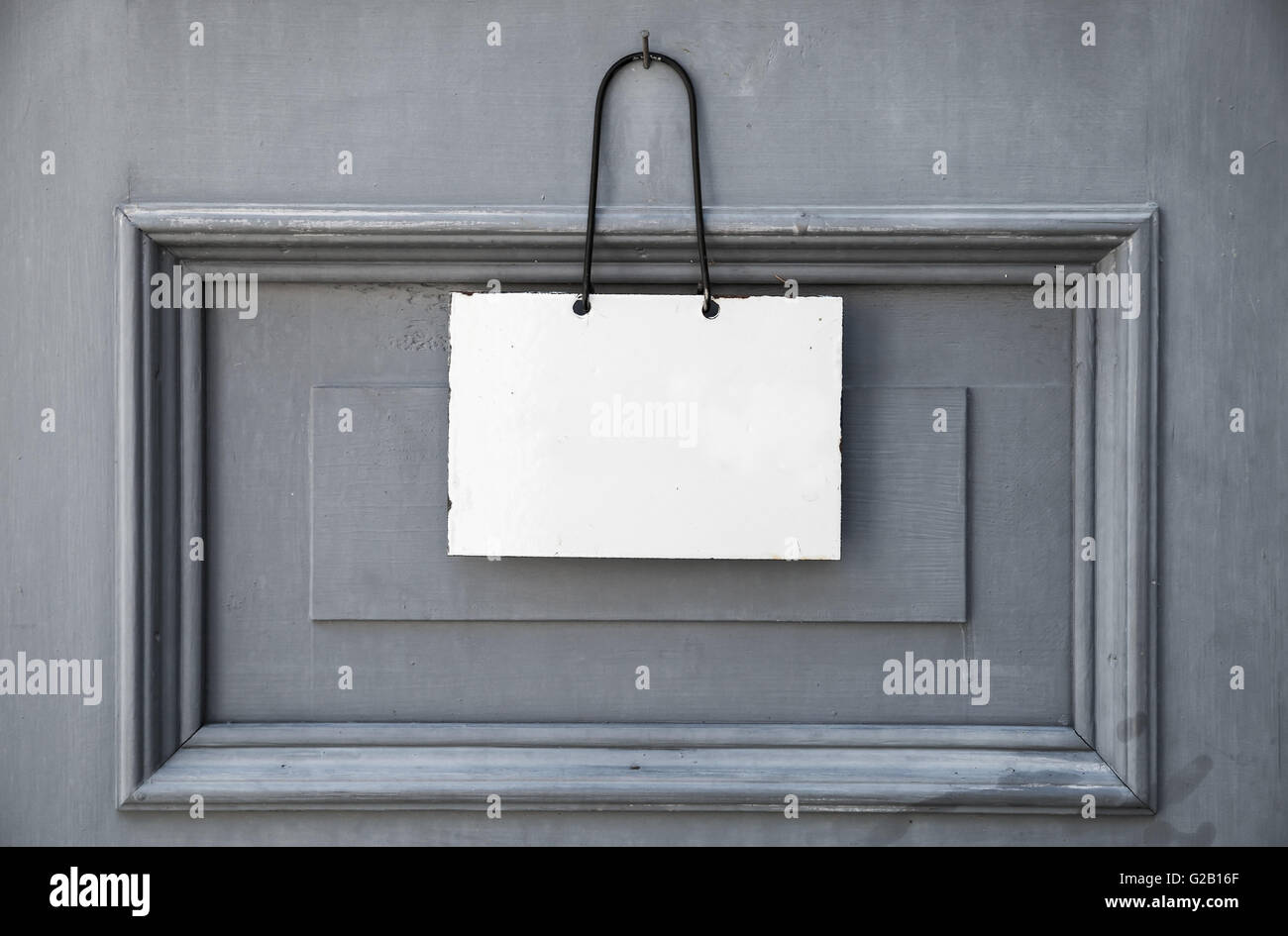 Leere weiße Platte für Informationstext hängen graue Holztür Stockfoto