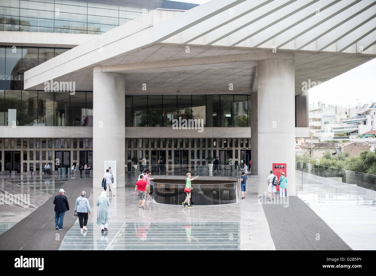 Eingang des Akropolis-Museums Athen Griechenland // ATHEN, Griechenland — das 2009 eröffnete neue Akropolis-Museum beherbergt alle Artefakte, die aus dem antiken Akopolis und seiner unmittelbaren Umgebung stammen. Es wurde 2009 für die Öffentlichkeit geöffnet und befindet sich auf der archäologischen Stätte von Makrygianni, von der ein Teil am Vordereingang des Museums besichtigt werden kann. Stockfoto