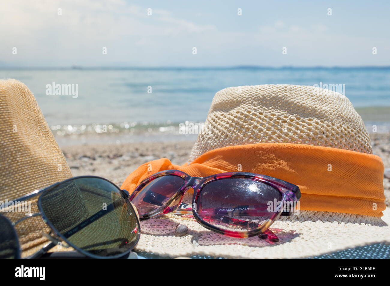 Zwei Strohhut und Sonnenbrille am Strand an einem sonnigen Tag Stockfoto