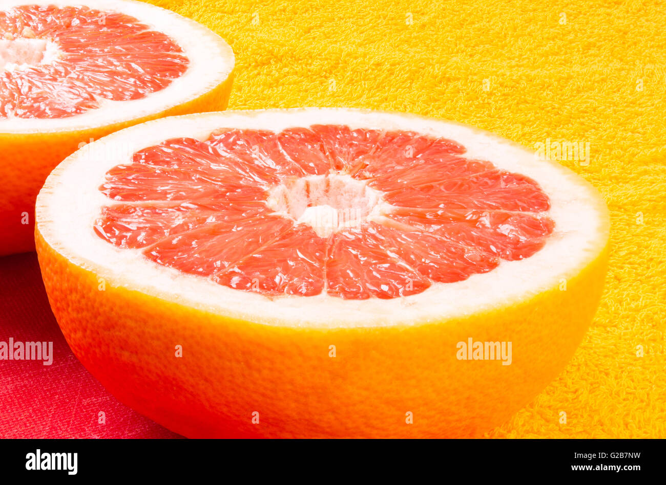 zwei Hälften der Grapefruit auf gelbem Hintergrund Stockfoto