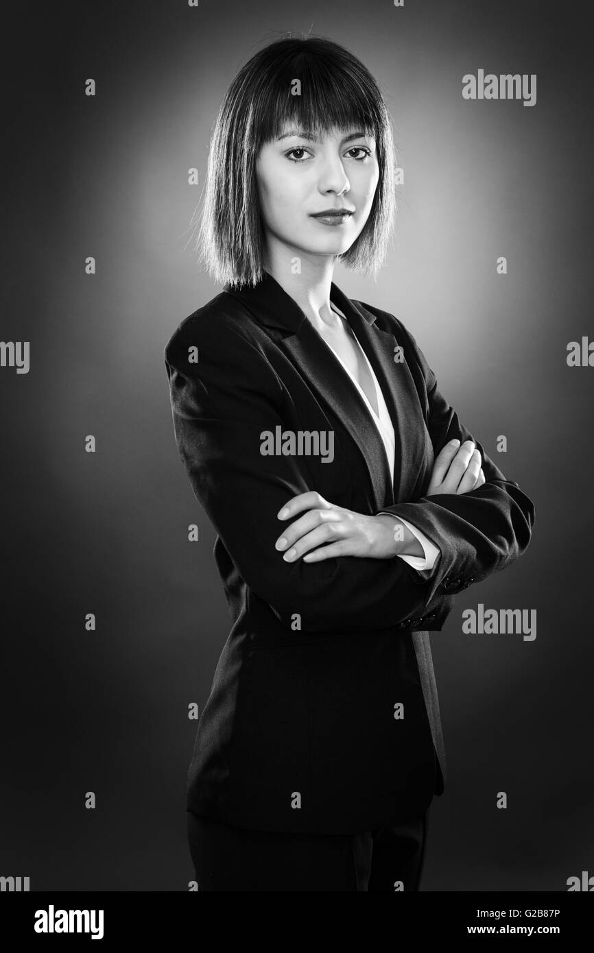 professionell aussehende Geschäftsfrau Blick auf niedrige wichtige Kamerabeleuchtung erschossen auf einem grauen Hintergrund Stockfoto