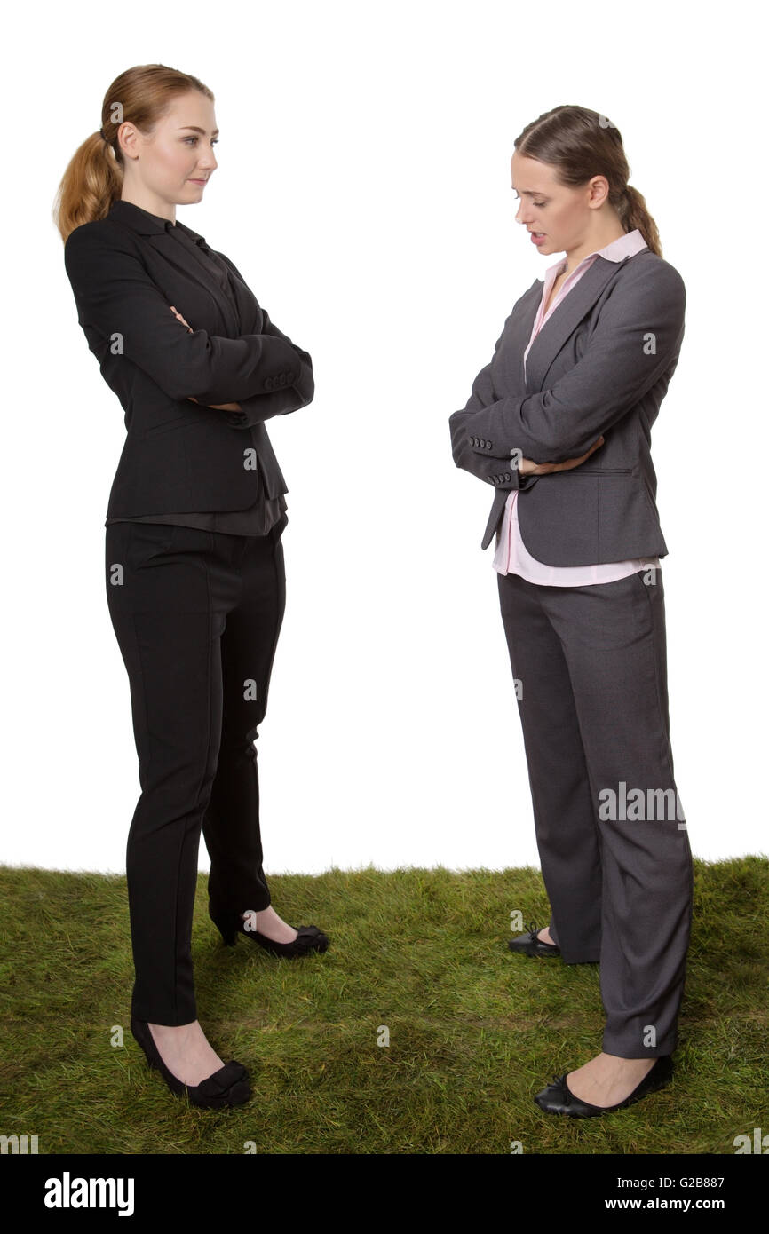 Aufnahme von zwei erfolgreiche weibliche Geschäftsmodelle posieren stehend auf dem Rasen Einschätzung einander Stockfoto