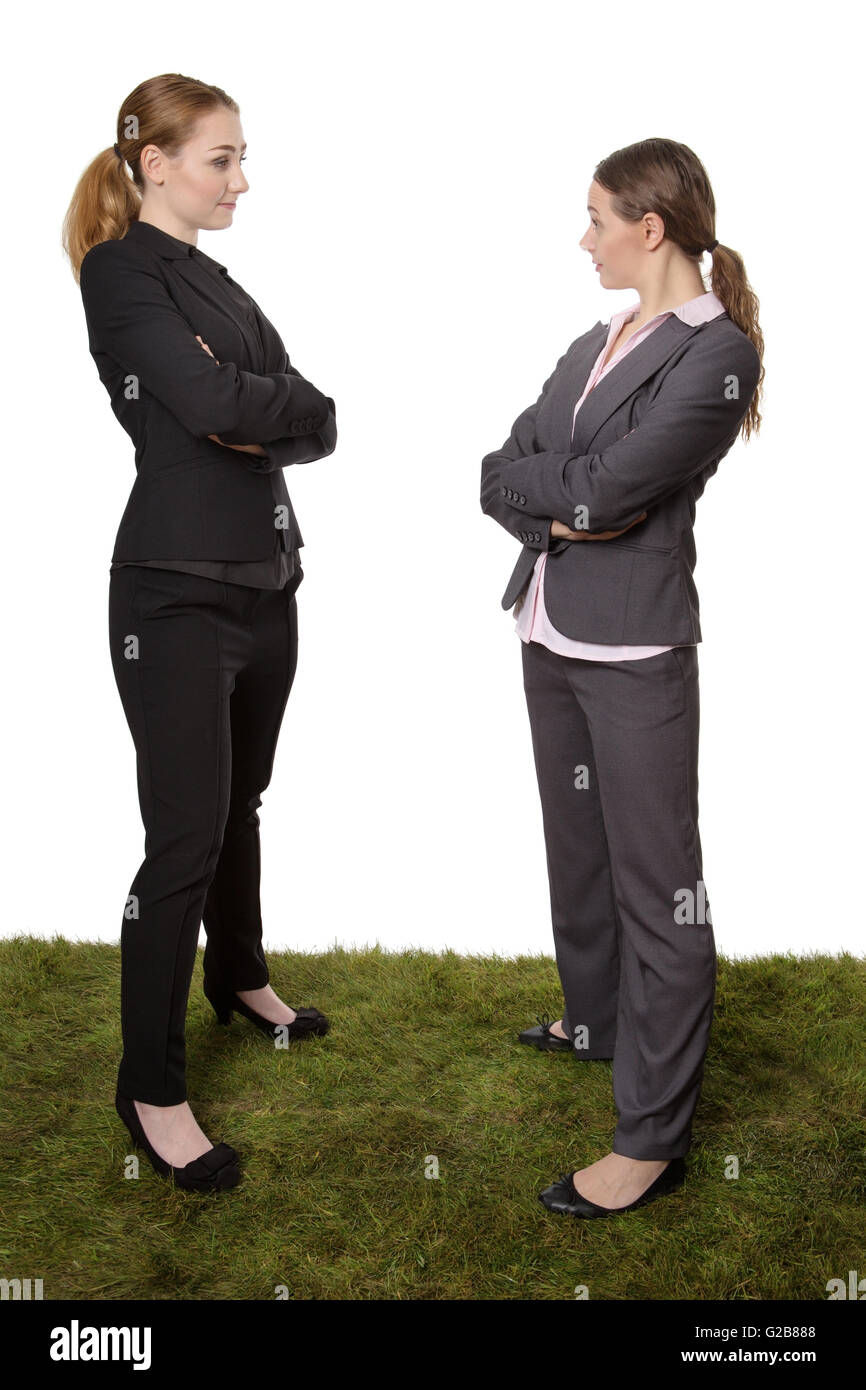 Aufnahme von zwei erfolgreiche weibliche Geschäftsmodelle posieren stehend auf dem Rasen Einschätzung einander Stockfoto