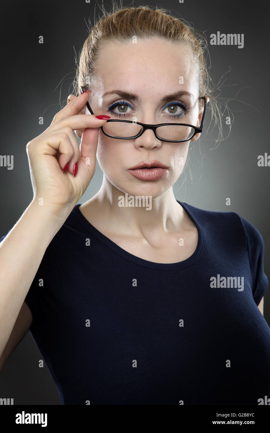 Studioaufnahme von eine attraktive, ernst aussehende Business Frau mit Brille, mit ihrem Haar wieder weg von ihrem Gesicht gebunden.  Sie ich Stockfoto