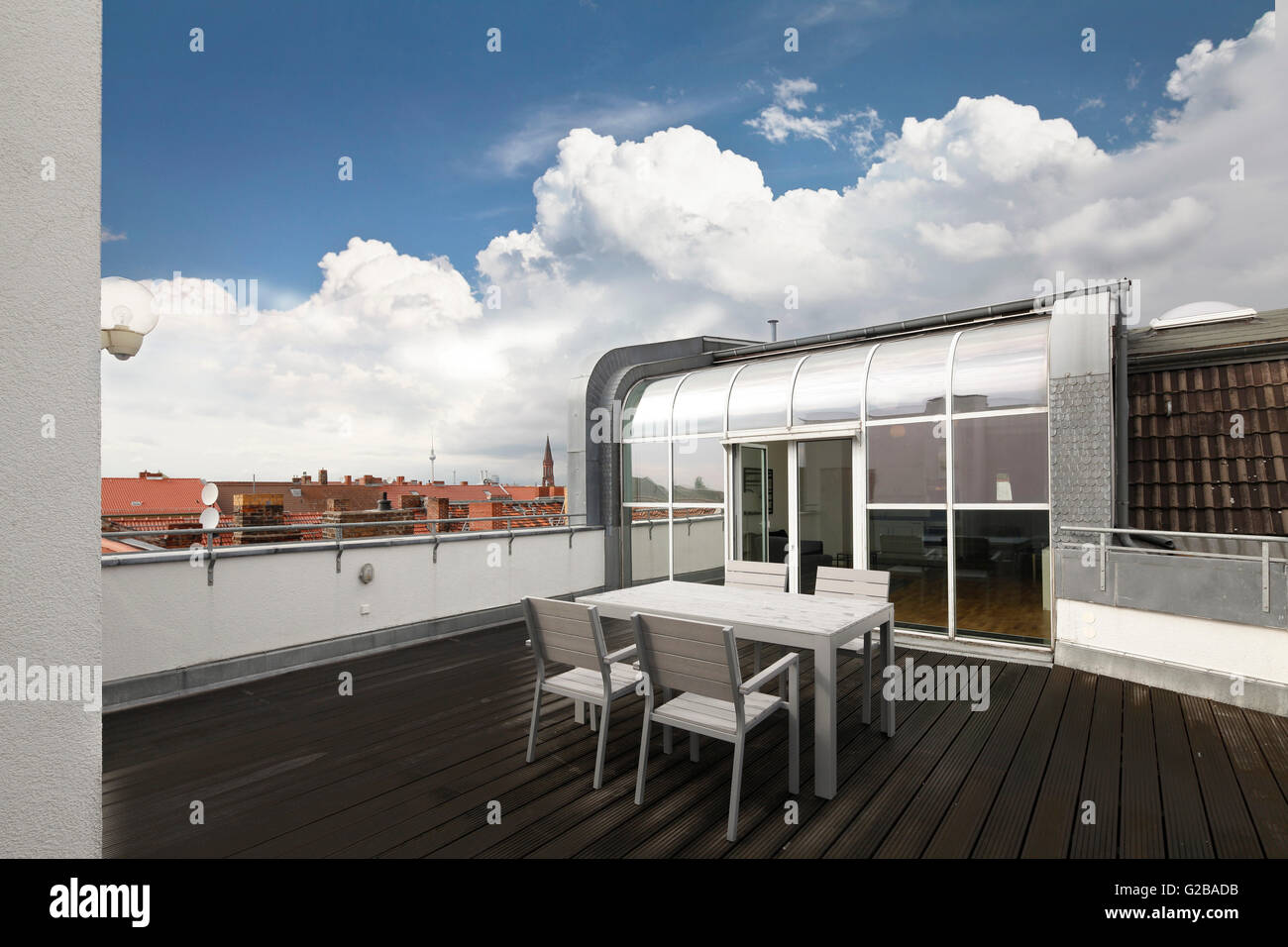 Umwandlung von Dach oder Dachboden in der Reichenberger Straße in Kreuzberg. Holzterrassen außerhalb der Dachboden mit Esstisch und Stühlen. Glas Terrassentüren und Decke bis zum Boden Windows. Stockfoto