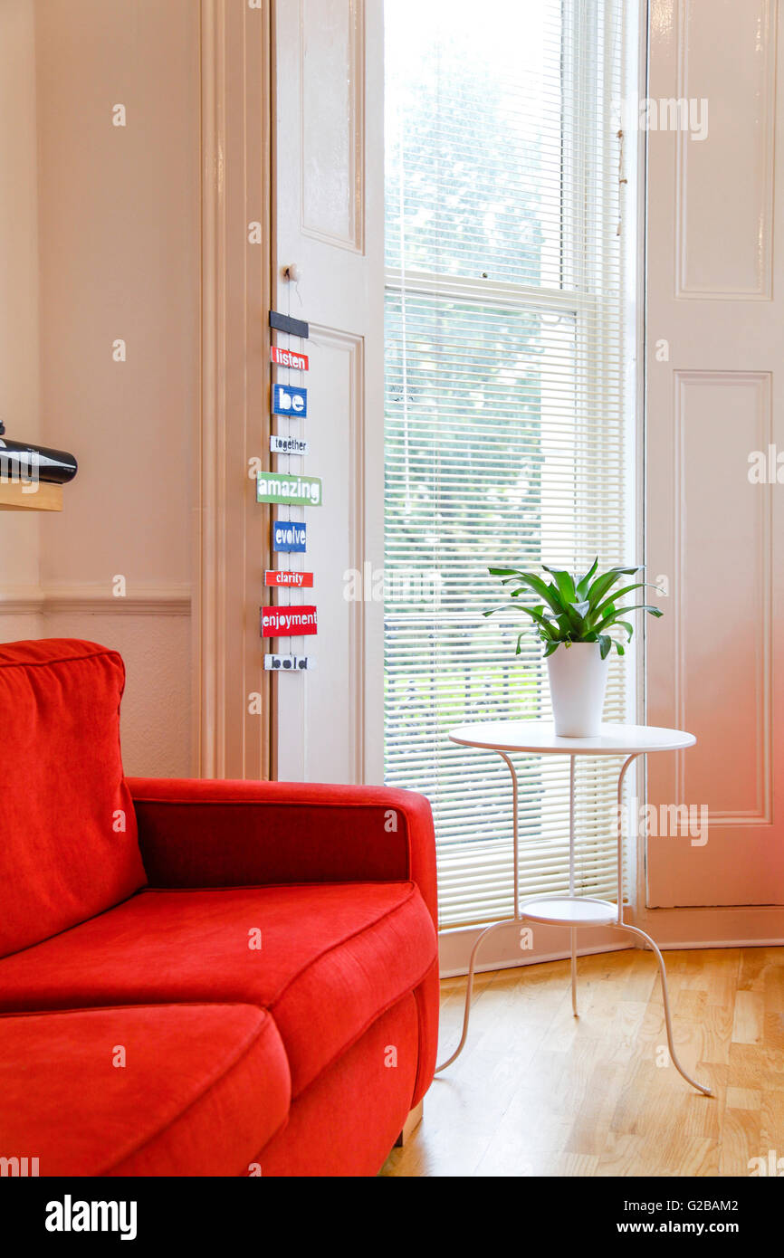 Pembridge Square, Notting Hill. Parial Blick auf einer roten Couch im Wohnzimmer. Stockfoto