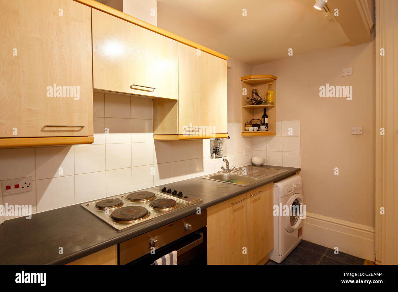 Pembridge Square, Notting Hill. Blick auf eine ältere, typische Küche. Holz Schränke und weiße Waschmaschine. Stockfoto