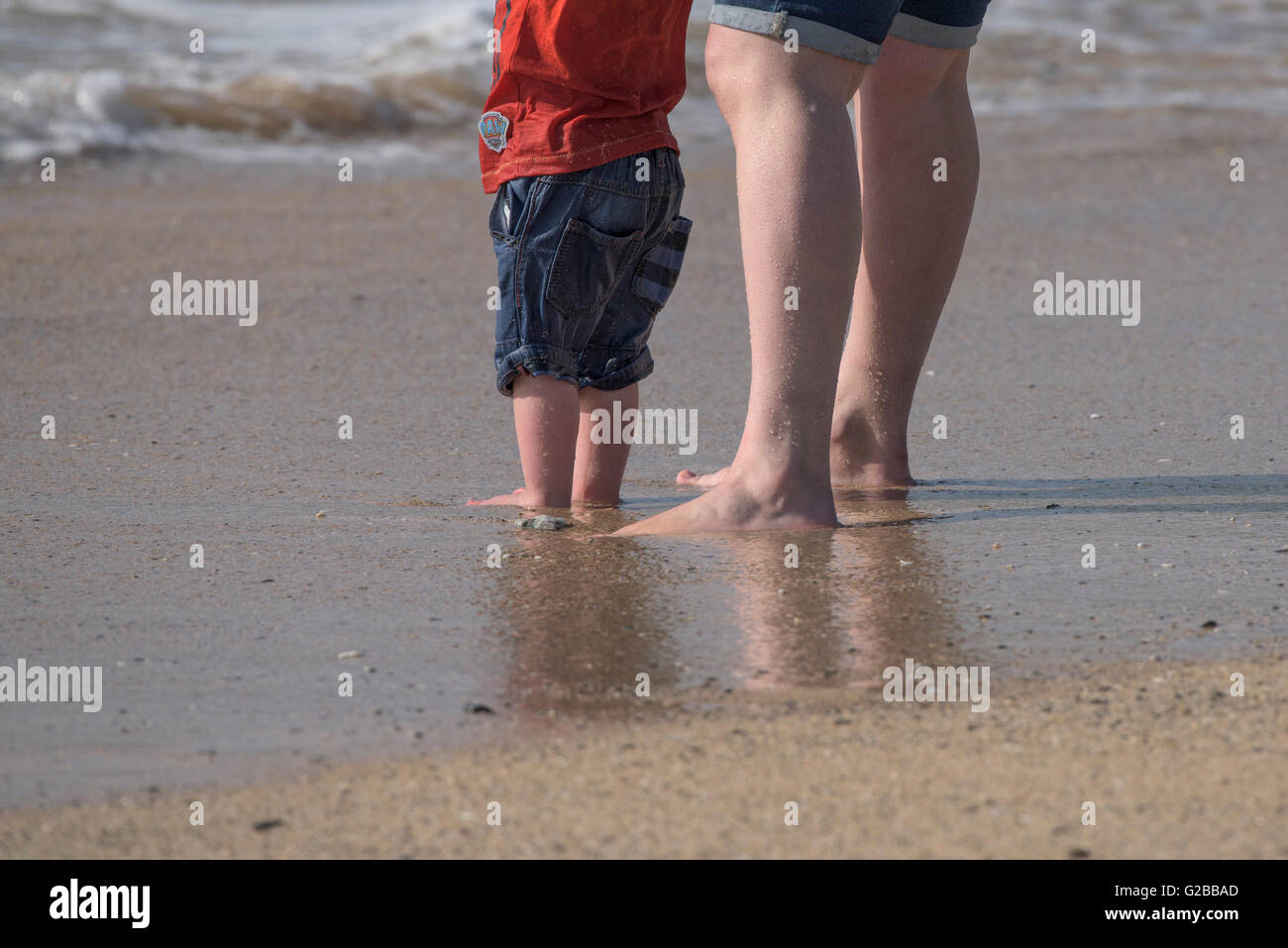 Mutter und Kind stehen an der Küste am Fistral Beach in Newquay, Cornwall. Stockfoto