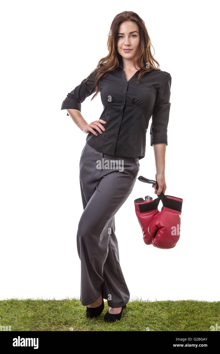 SLim-Modell einen Business-Anzug tragen, einige Boxhandschuhe in einer Hand hält, auf dem Rasen stehen. Stockfoto