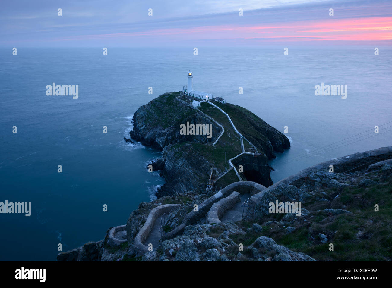 South Stack Lighthouse, Anglesey, einer farbenfrohen Sonnenuntergang. Stockfoto