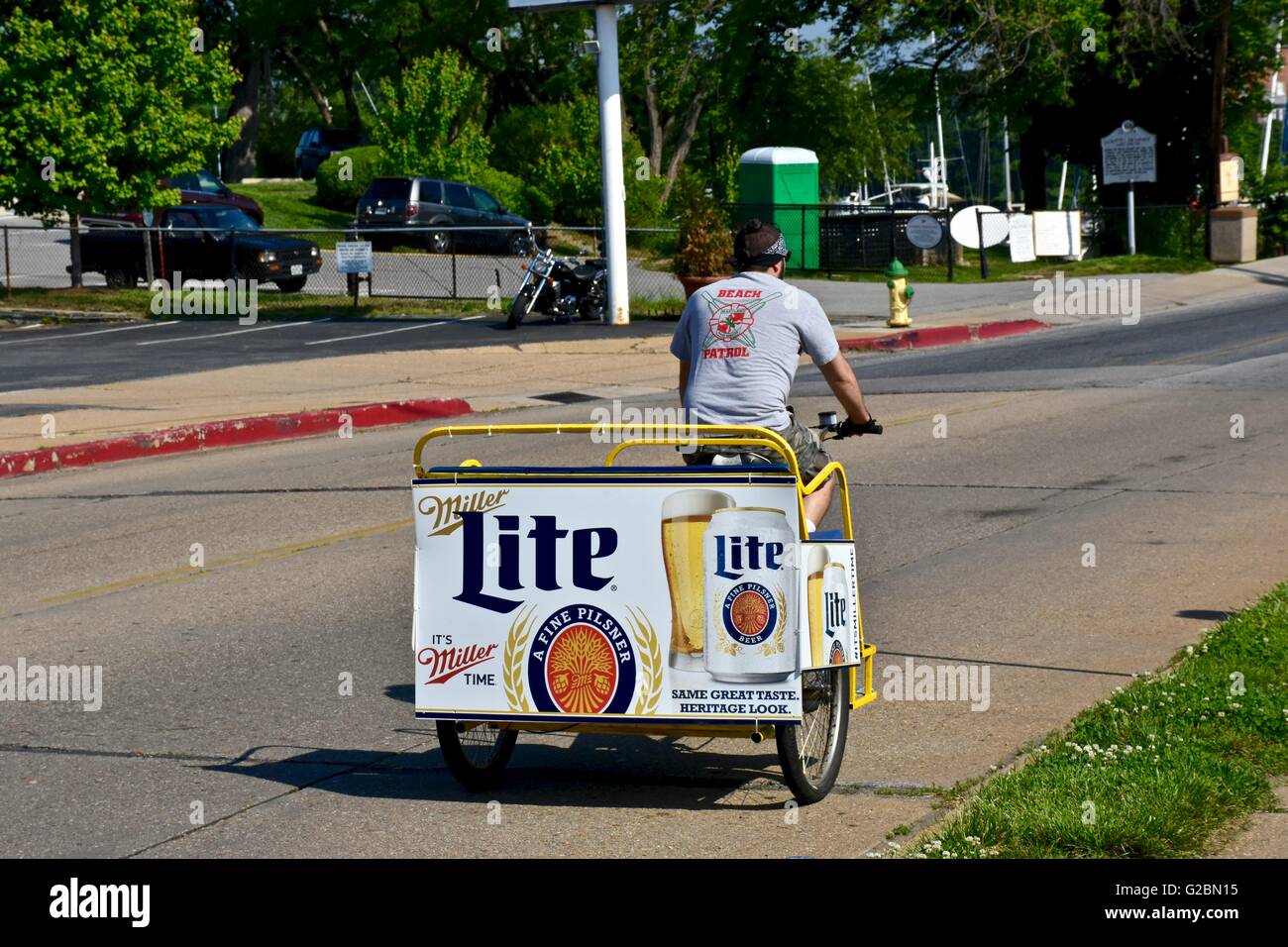Ein Mann Reiten ein Motorrad-Taxi mit einem Miller Lite Poster auf der Rückseite des Wagens Stockfoto