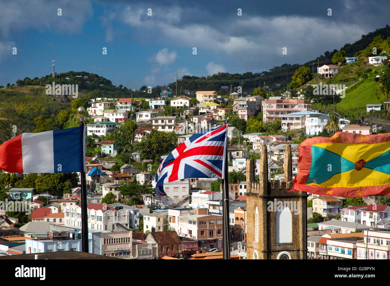 Flaggen aus Frankreich, Großbritannien und Grenada überfliegen von Fort George St. Andrews Presbyterian Church und Stadt St. Georges, Grenada Stockfoto