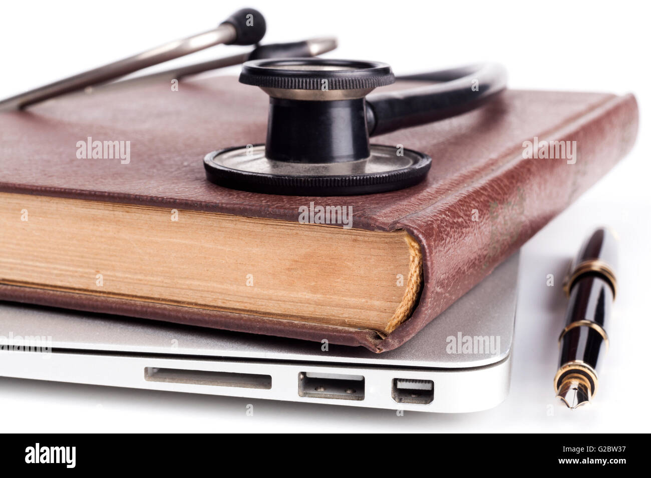 Altes Buch auf Silber Laptop isoliert auf weißem Mentorprogramm Stockfoto