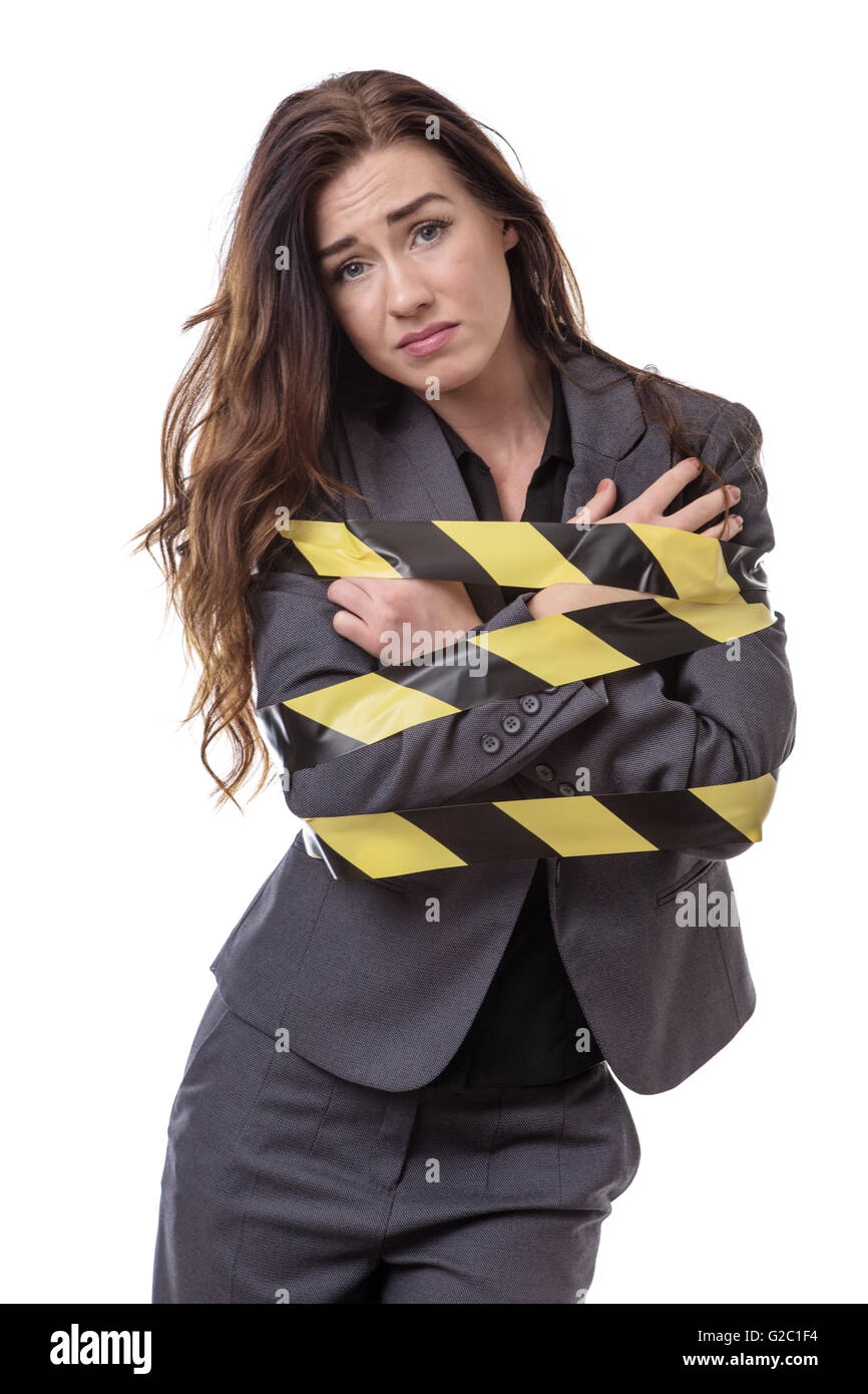 Geschäftsfrau, eingehüllt in gelben und schwarzen Klebeband isoliert auf weiss Stockfoto