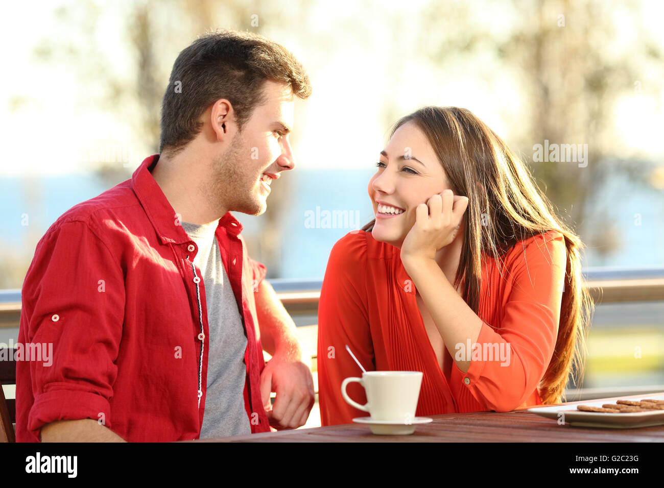 Ehrliche paar Datum fallen in Liebe flirten in eine Terrasse mit Blick auf einander zärtlich küssen denken Stockfoto