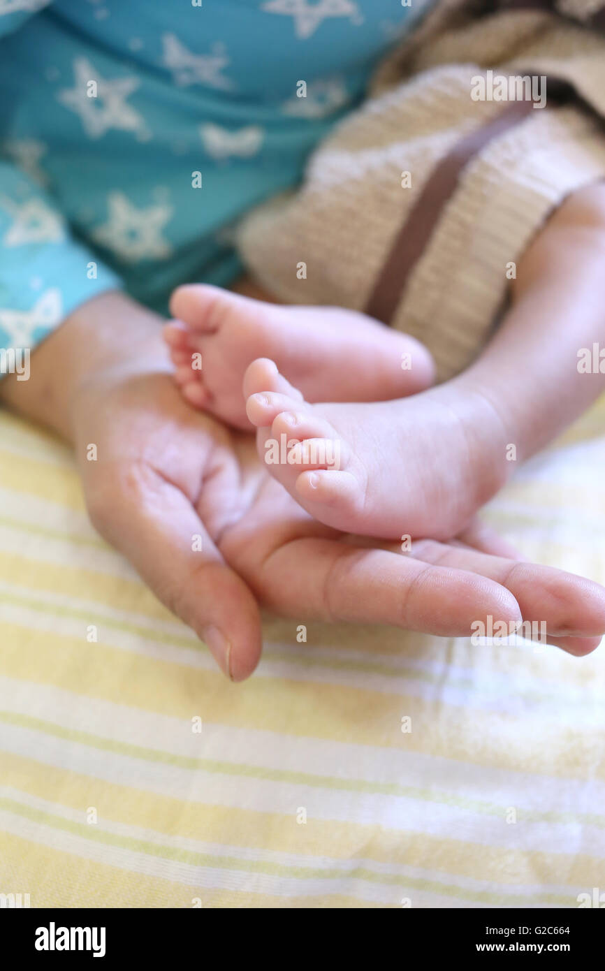 Baby Füße in Mom hand aufs Alter ungefähr einen Monat. Stockfoto