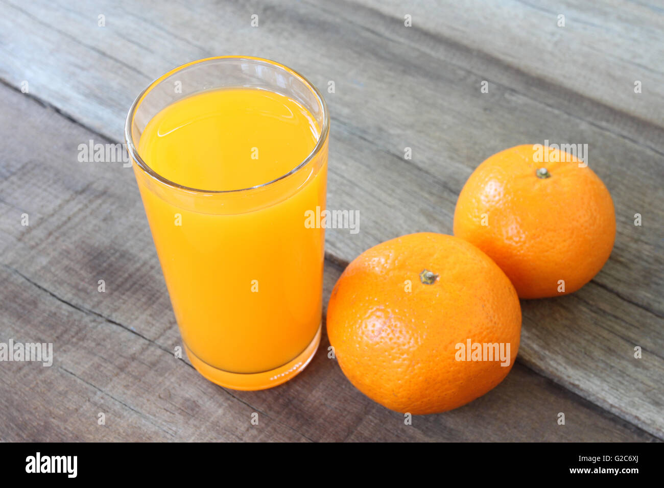 frische orange Frucht auf Holzboden gelegt und Saft im Glas zum Konzept einer gesunden Ernährung haben. Stockfoto