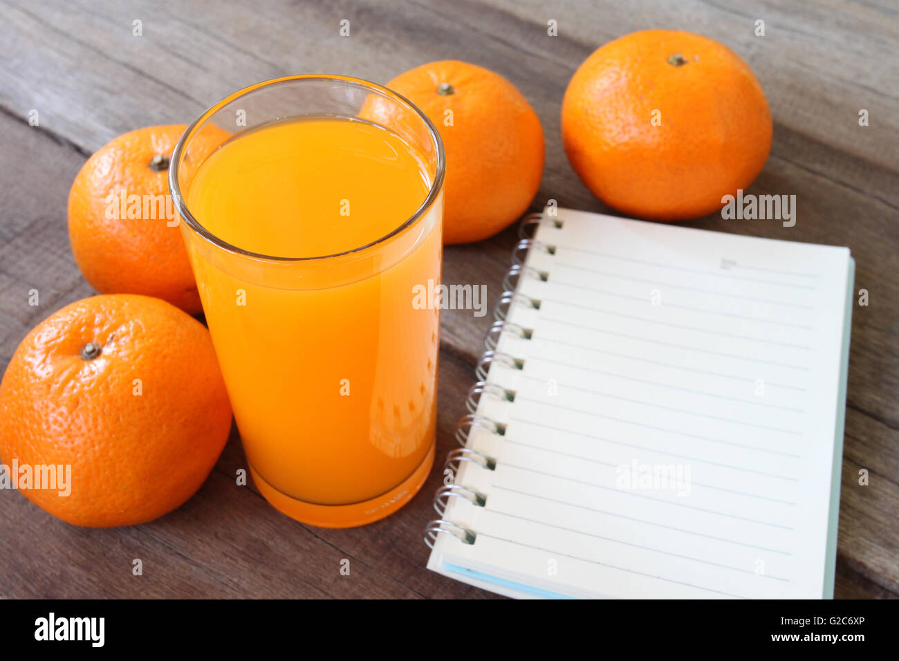 frische orange Frucht auf Holzboden gelegt und Saft im Glas zum Konzept einer gesunden Ernährung haben. Stockfoto