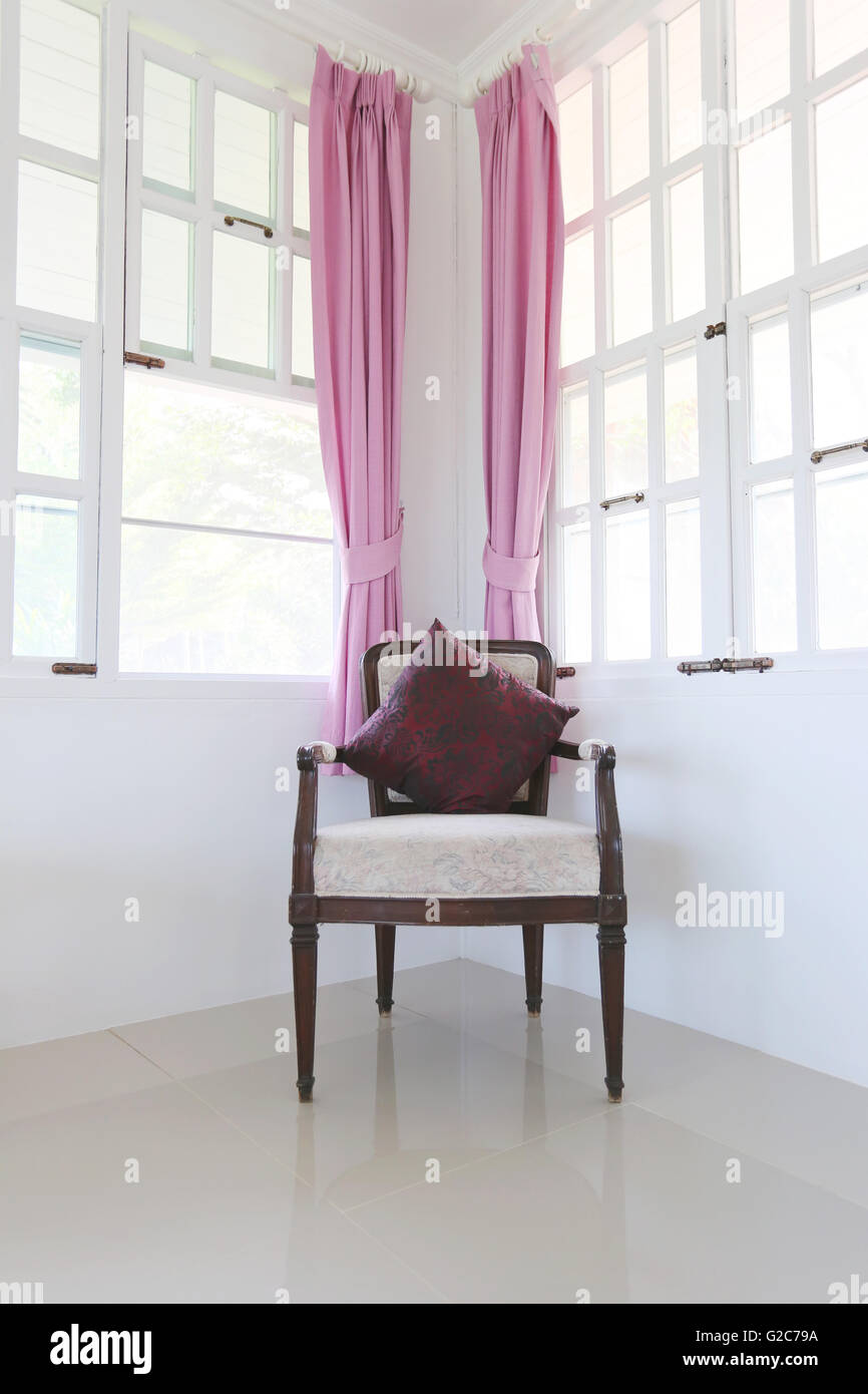 Vintage Antik Sessel im Wohnzimmer mit Fenster und Jalousien rosa. Stockfoto