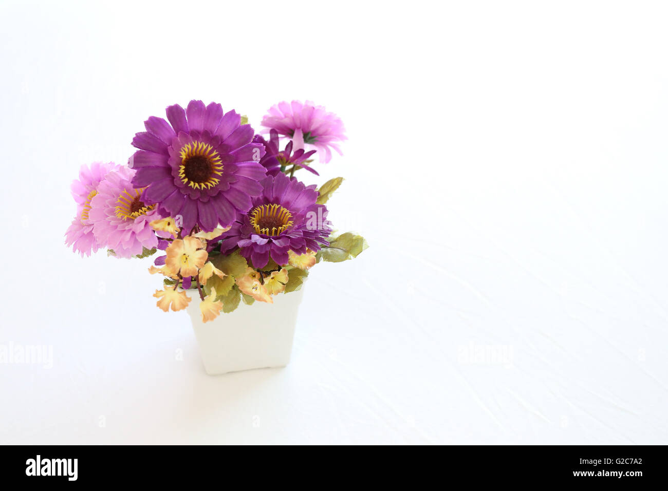 Vintage pink und violett künstliche Blumen auf weißem Stoff im Schlafzimmer Innenraum-Konzept und Design. Stockfoto