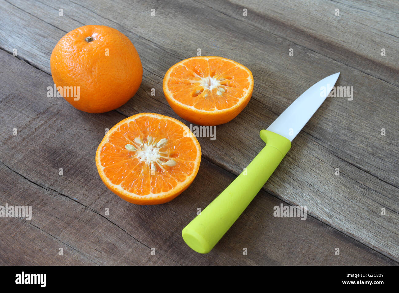 frische orange Frucht auf Holzboden gelegt und haben Messer Acryl-Konzept für eine gesunde Ernährung. Stockfoto