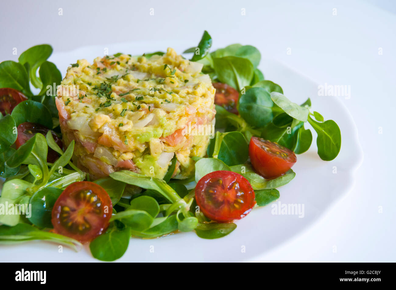 Lachs, Avocado und Zwiebel Kuchen mit Wasser Kresse und Cherry-Tomaten-Salat. Schließen Sie die Ansicht. Stockfoto