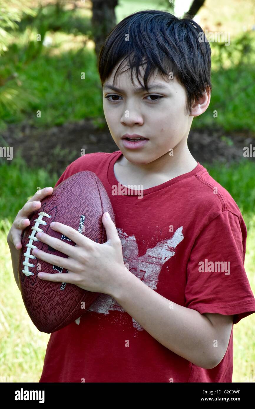 Ein kleiner Junge spielt Fußball in einem Feld Stockfoto