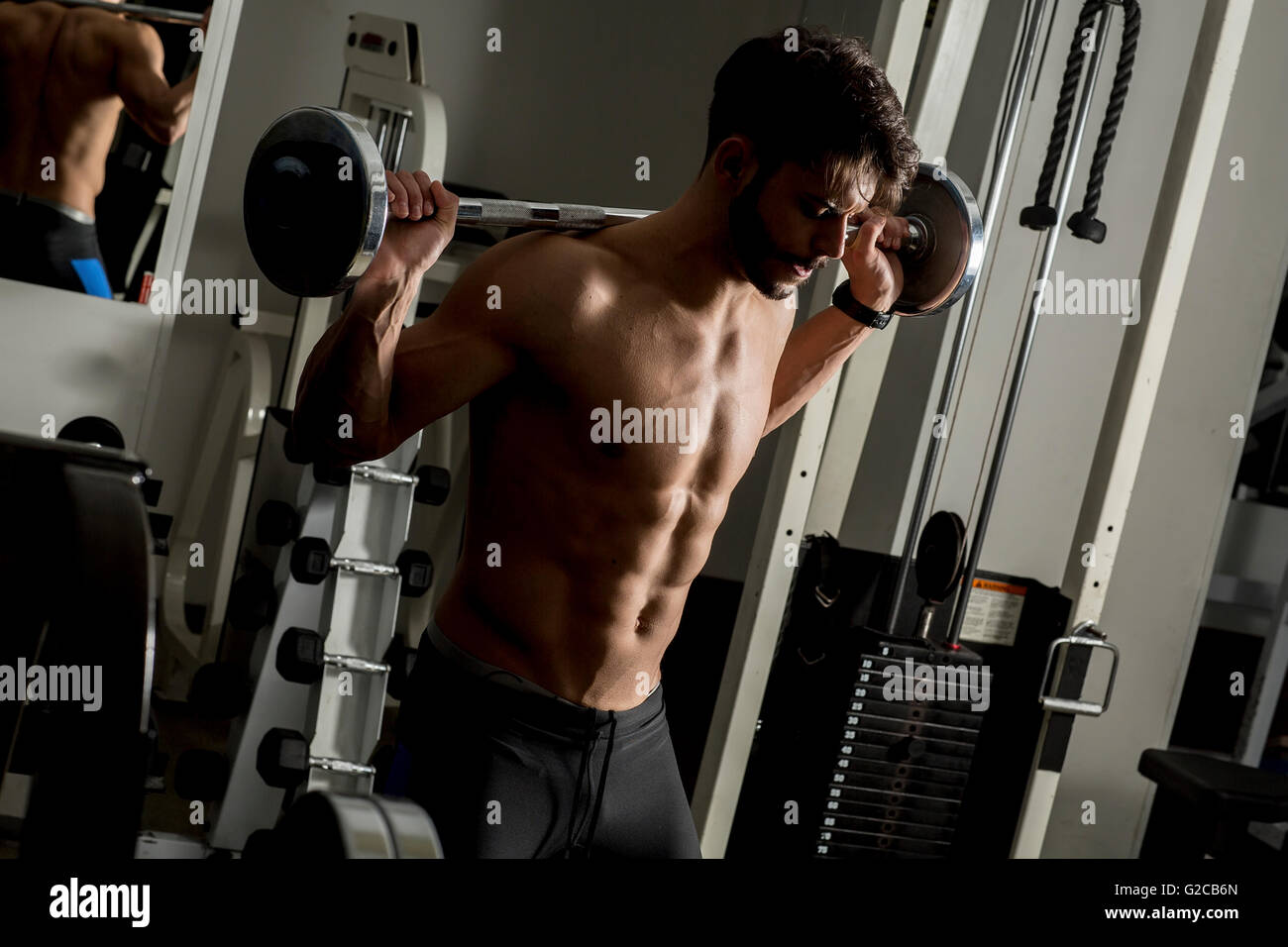 Junger Mann Gewichtheben in der Turnhalle Stockfoto
