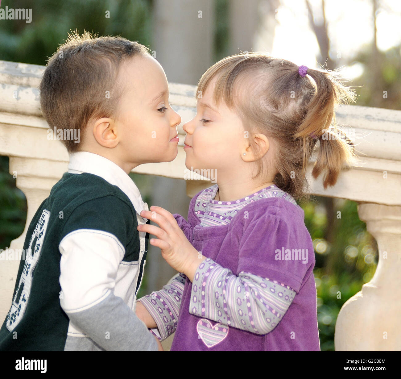 schüchternes Mädchen und jungen zärtlich küssen im park Stockfoto