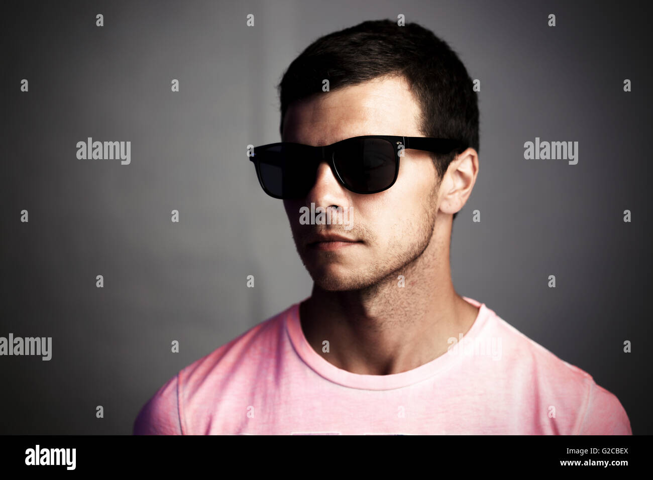 Dunkle Porträt eines jungen Mannes mit Sonnenbrille, soziale Isolation und Anonymität Konzept Stockfoto
