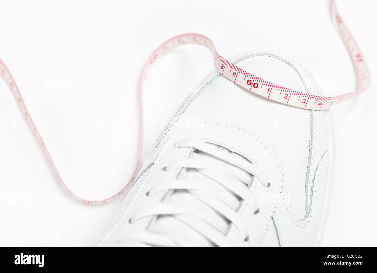 Meter mit 60 cm Marke über weißen Sportschuh. Gewicht-Verlust-Konzept Stockfoto