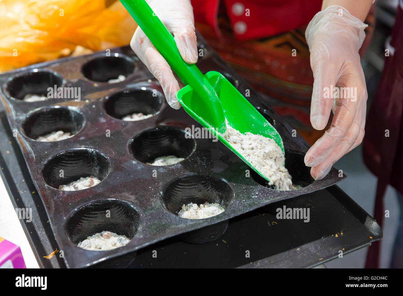 Frau weglegen Teig in Formen zum Backen Stockfoto