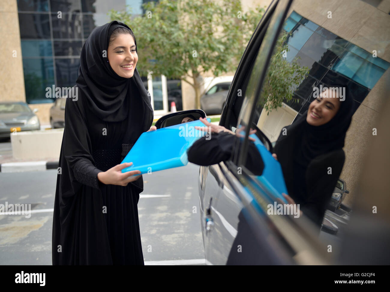 Emirati arabischen Geschäftsfrauen einsteigen in das Auto in Dubai, Vereinigte Arabische Emirate. Stockfoto