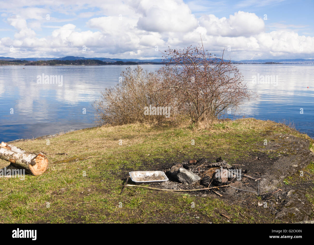 Picknickplatz auf dem Oslo-Fjord mit Resten eines Lagerfeuers Frühling in Vollen Asker Norwegen Stockfoto