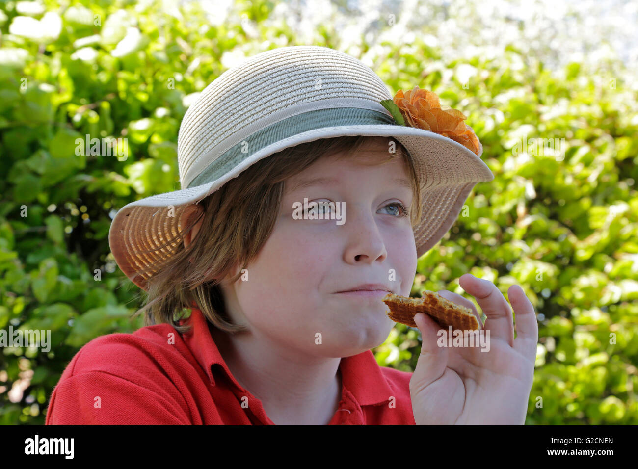 Junge mit Sonnenhut einen Keks essen Stockfoto