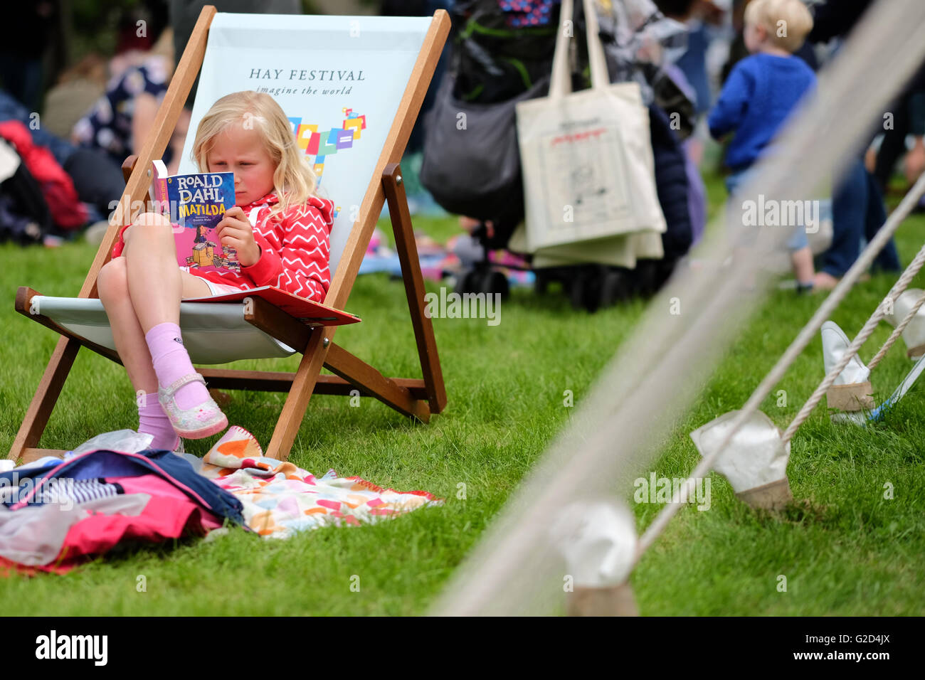 Hay Festival 2016 - Mai 2016 - Ein junges Mädchen sitzt und liest Matilda von Roald Dahl auf dem Festival rasen. In diesem Jahr wird der 100. Jahrestag der berühmten Autor, seine Bücher bleiben beliebt wie eh und je. Foto Steven Mai/Alamy leben Nachrichten Stockfoto