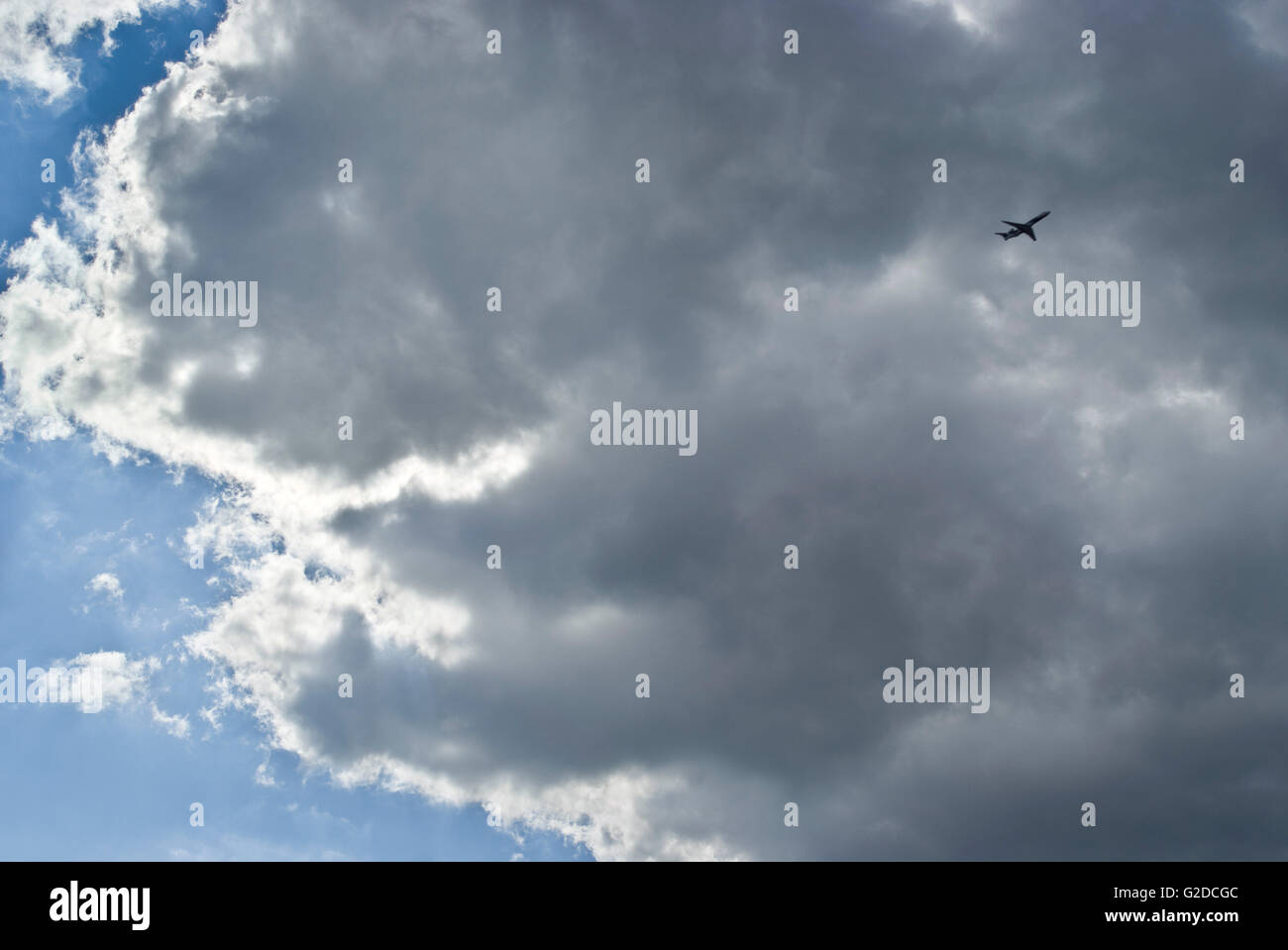 Flugzeug fliegen durch dunkle graue Wolke Stockfoto