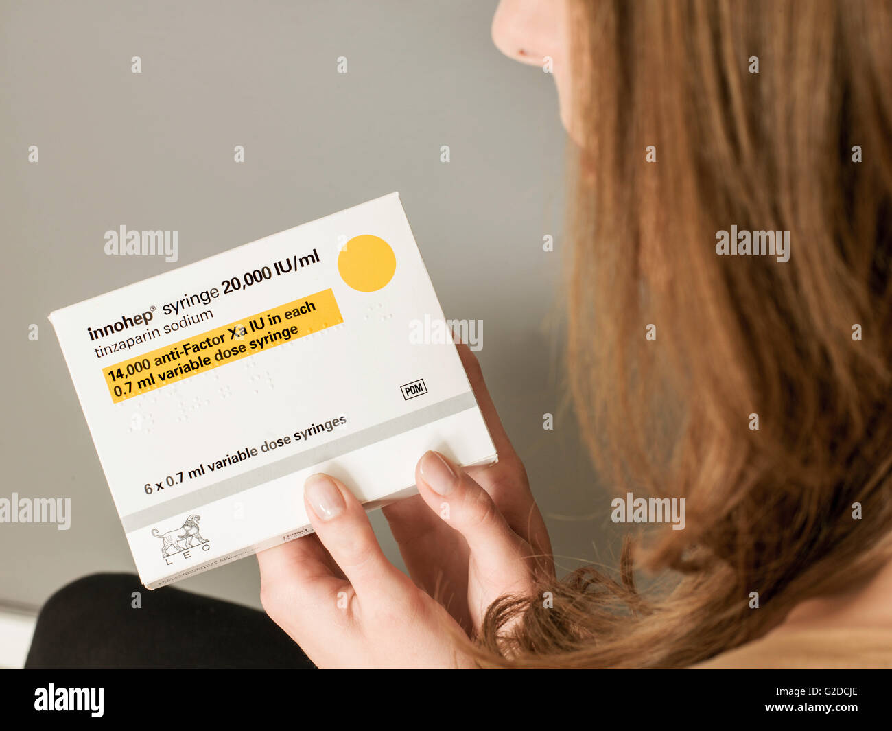 Junge Frau hält eine Packung Innohep blutverdünnende Spritzen Stockfoto