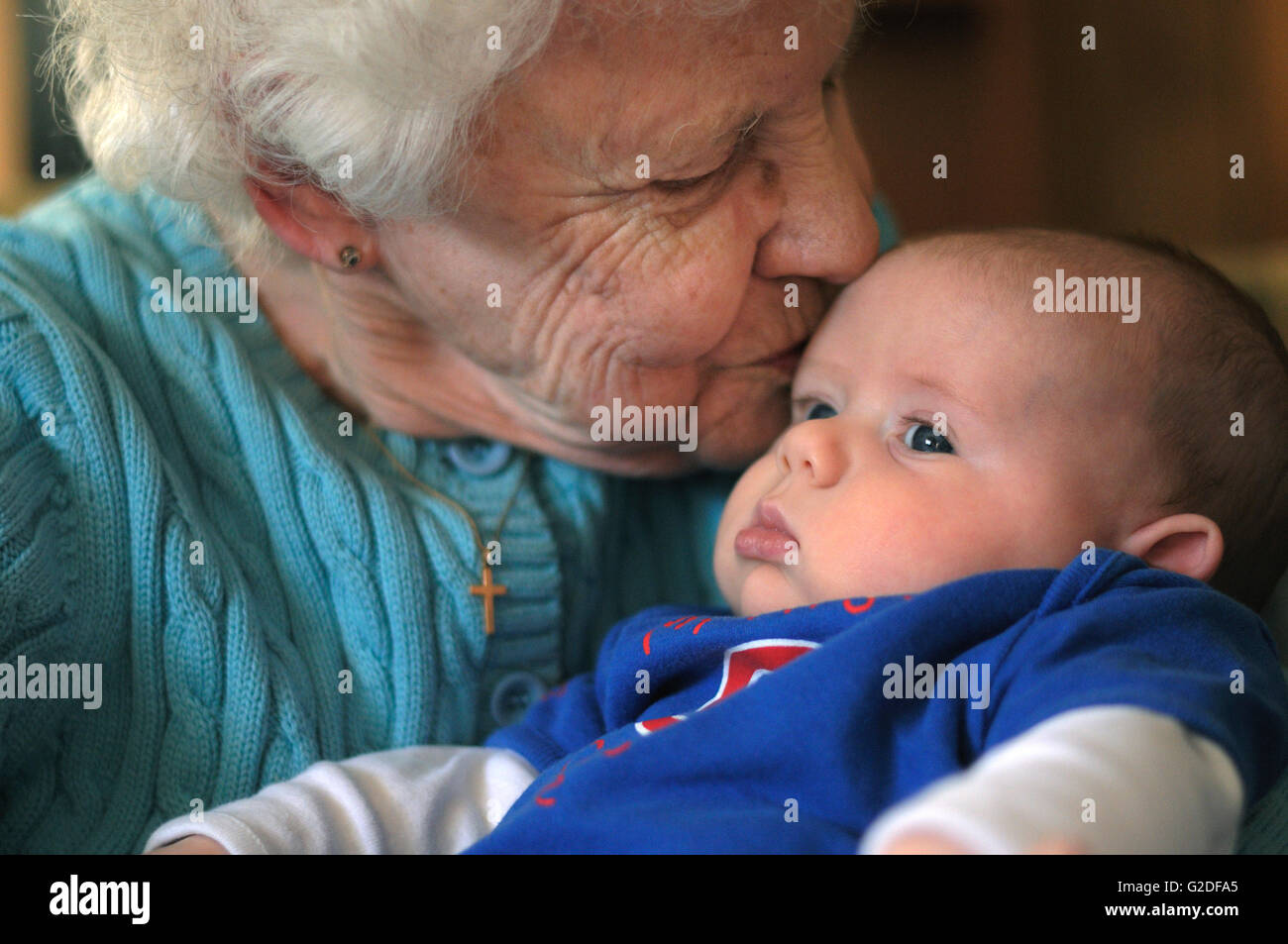 Urgroßmutter küssen Urenkel Stockfoto