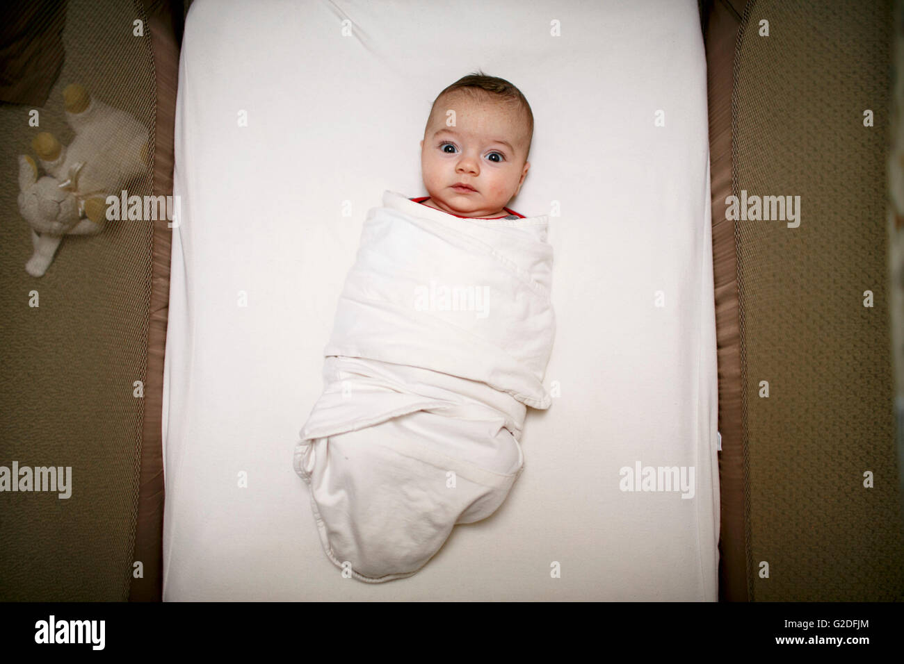 Mit weit aufgerissenen Augen Kleinkind in Decke gehüllt Stockfoto