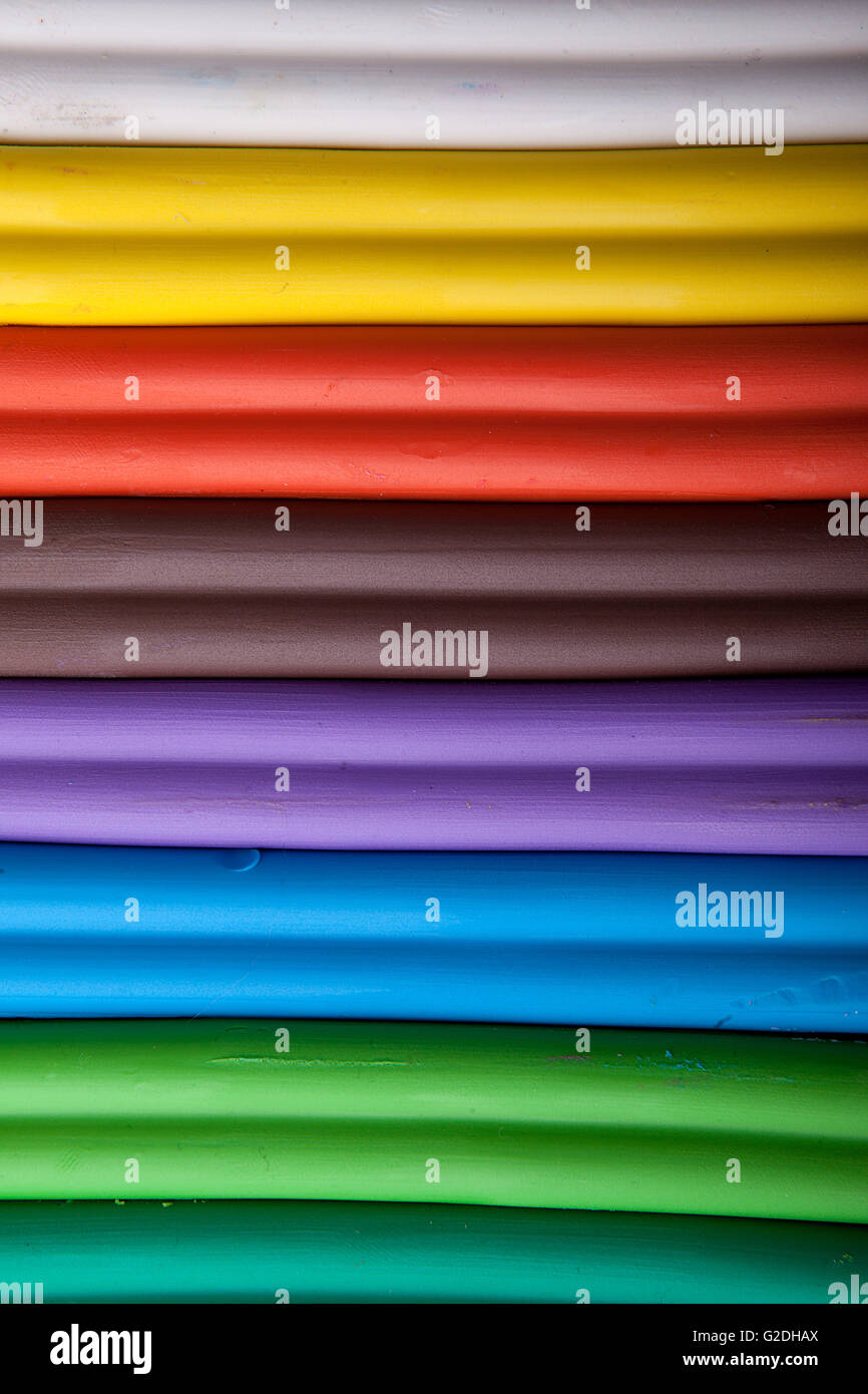 Viele Stücke von Knetmasse in verschiedenen Farben in einer Reihe ausgerichtet Stockfoto