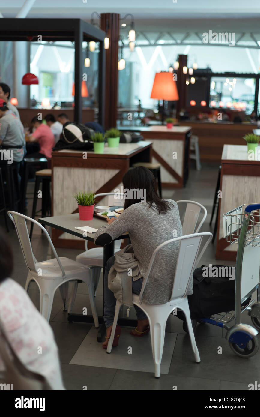 Junge Frau, die an ihr Mobiltelefon im stilvollen restaurant Stockfoto