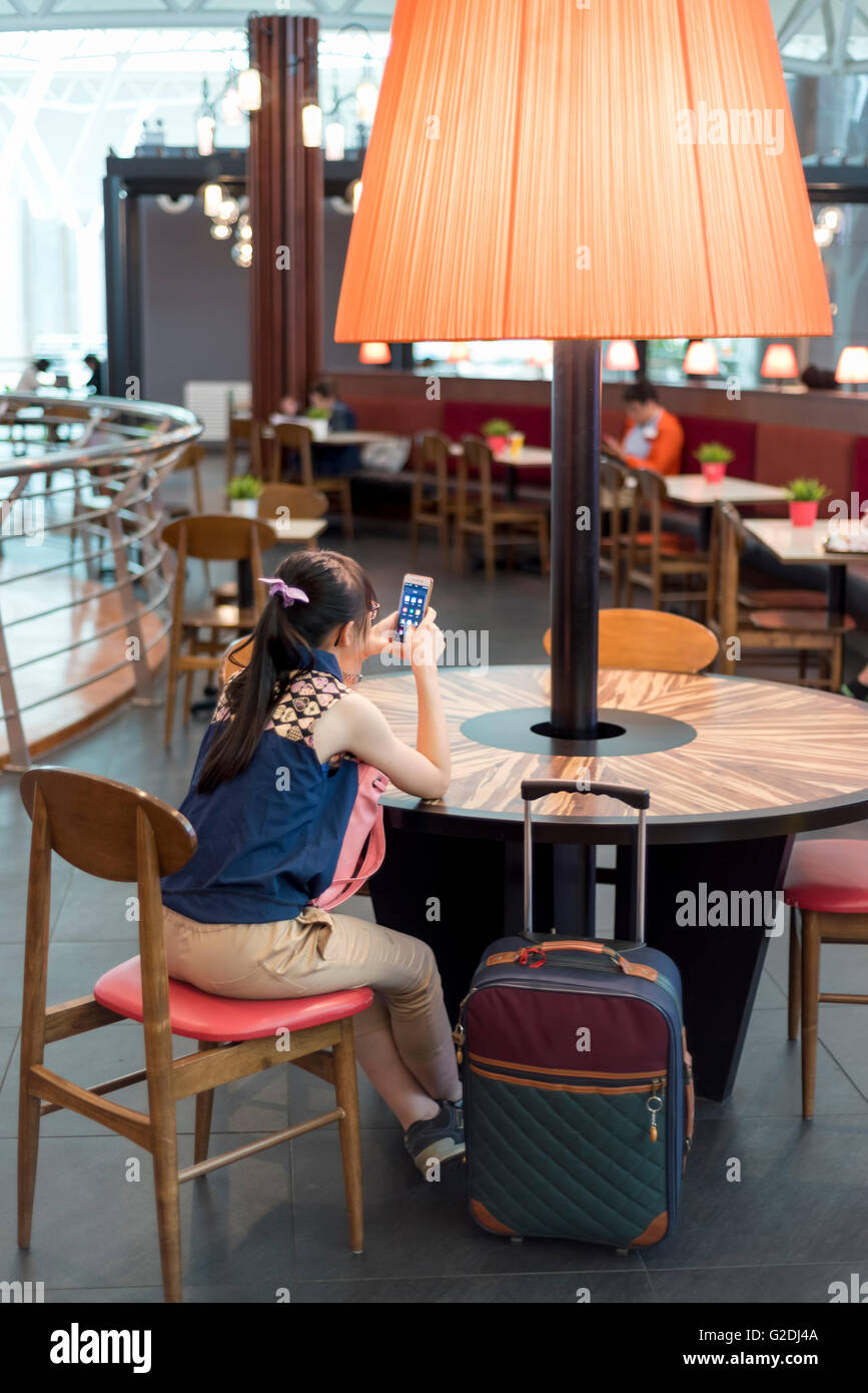 Junge Frau, die an ihr Mobiltelefon im stilvollen restaurant Stockfoto