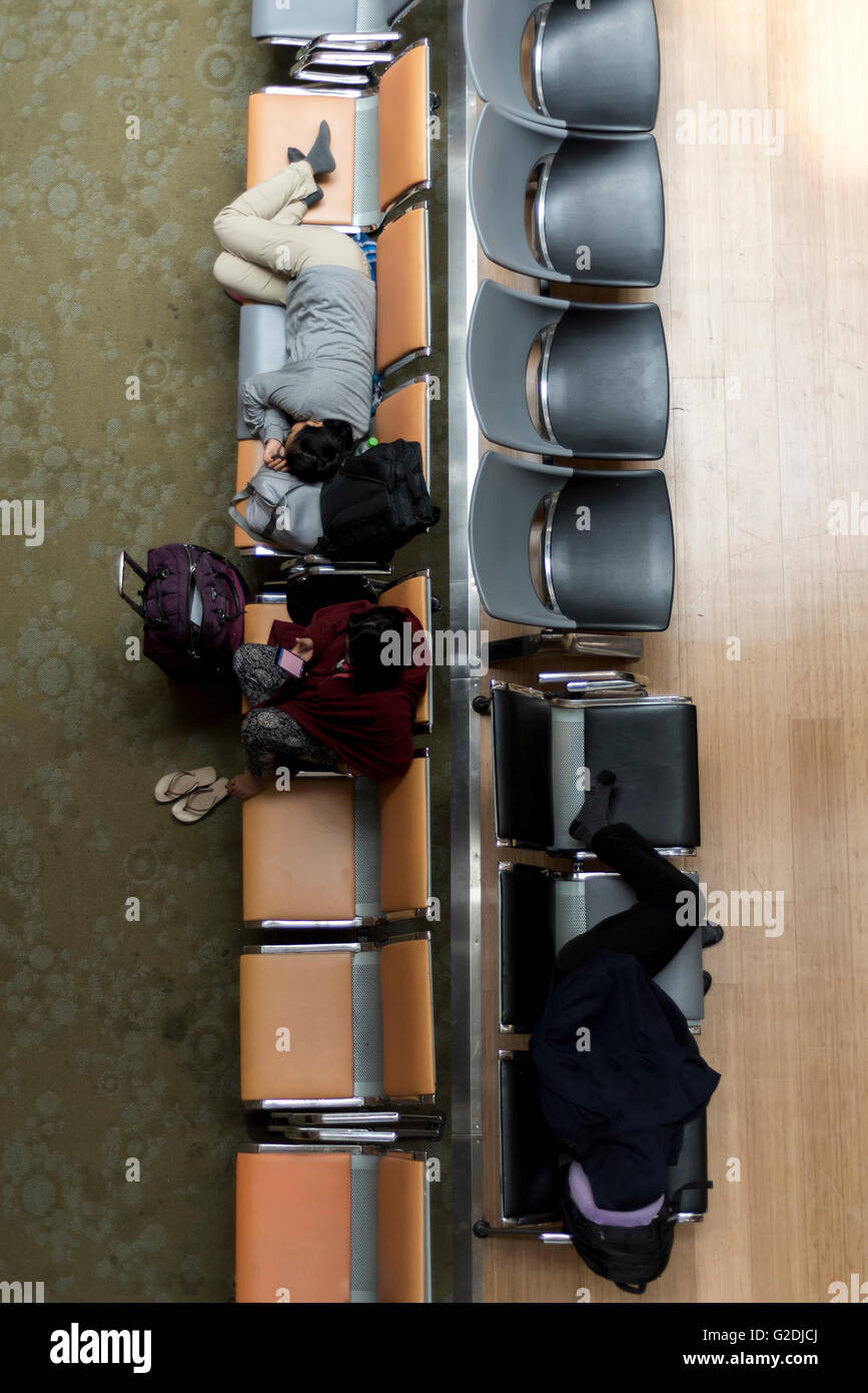 Die Menschen Sie warten und schlafen während des Wartens auf ihren Flug am Flughafen Stockfoto