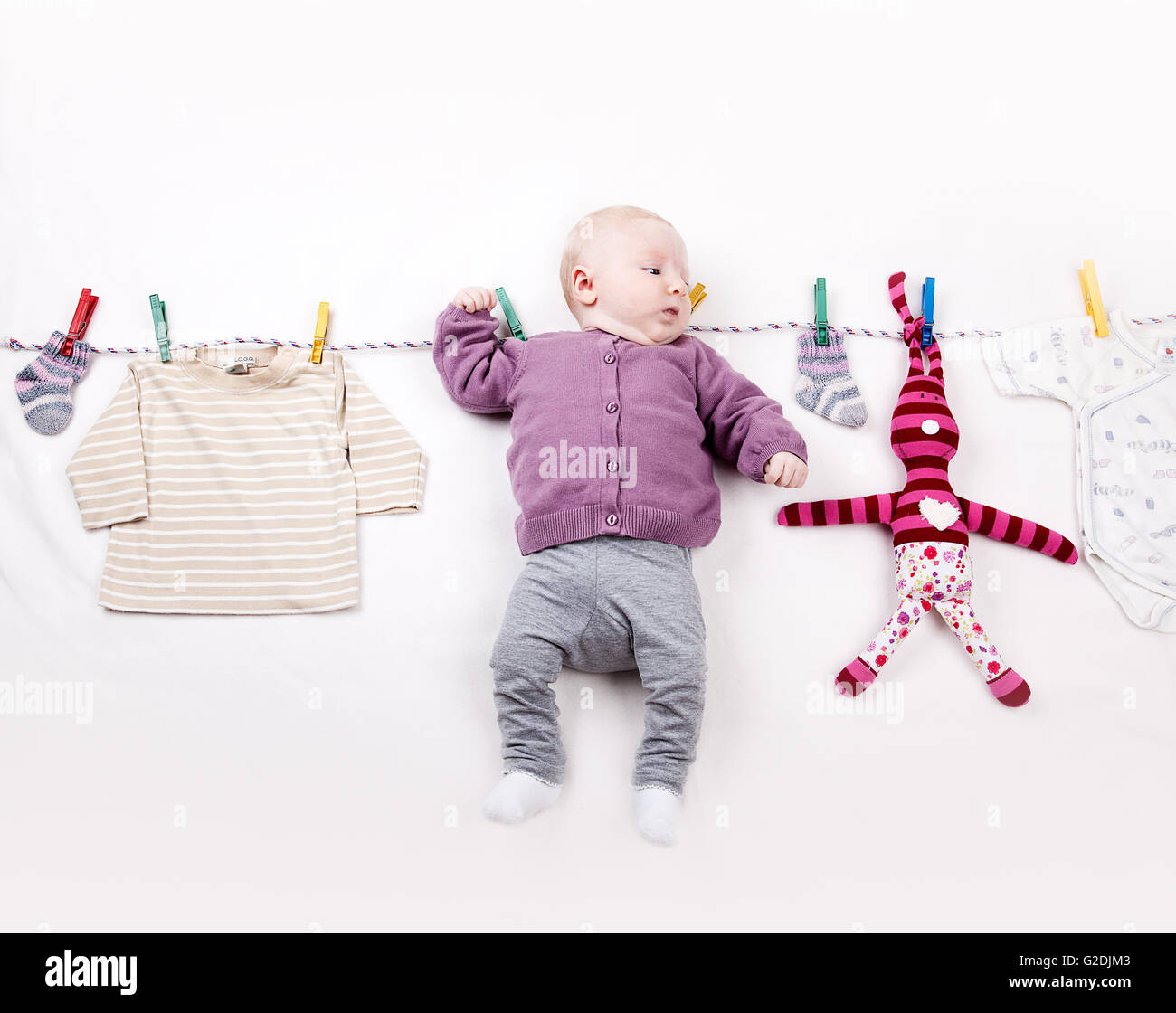 4 Monate altes Babymädchen hangin auf Wäscheleine Stockfoto