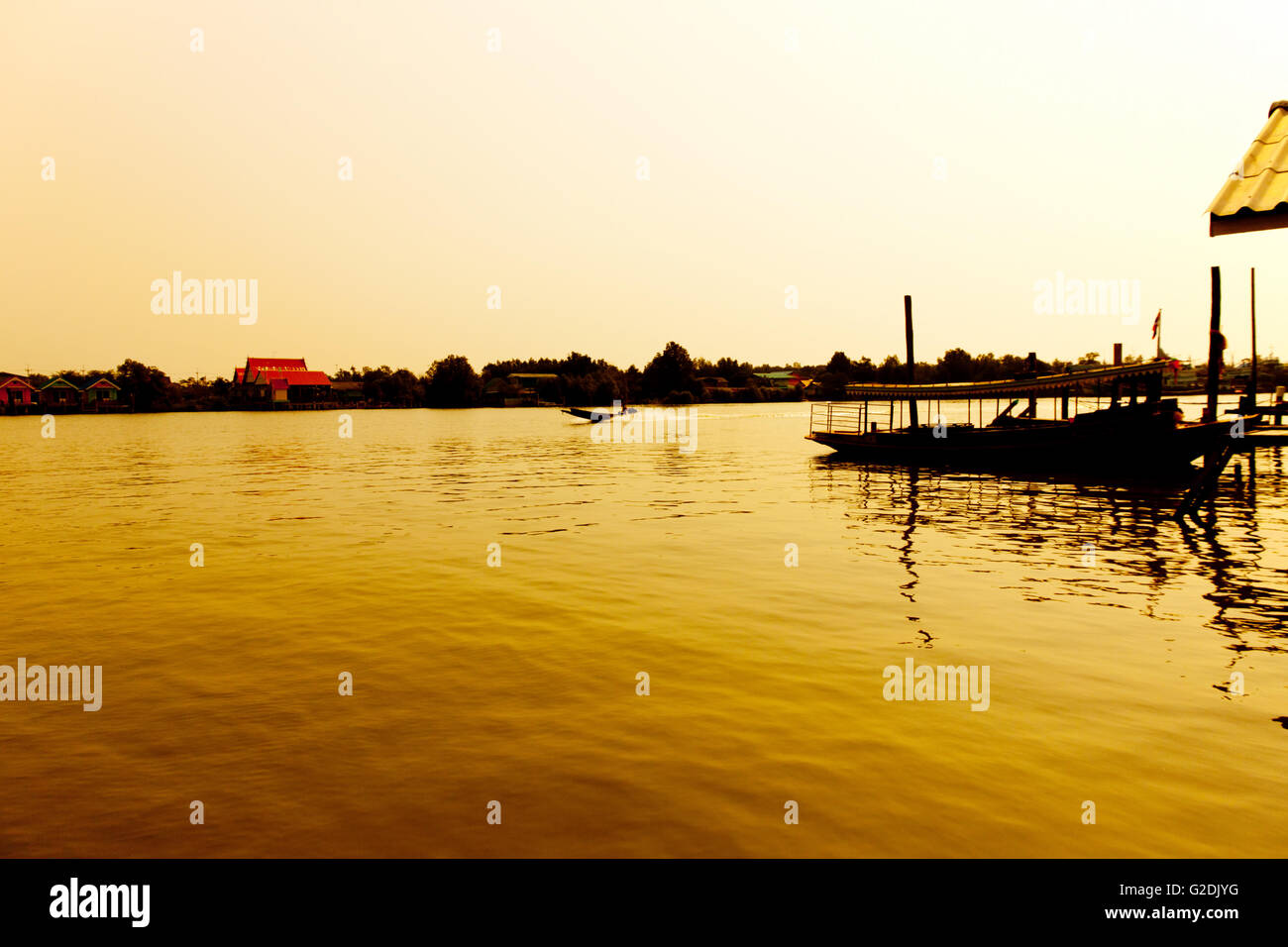 Lange Holz-Boot Heckmotor im Fluss in der Morgendämmerung mit goldenem Licht. Sonnenaufgang mit silhouette Stockfoto