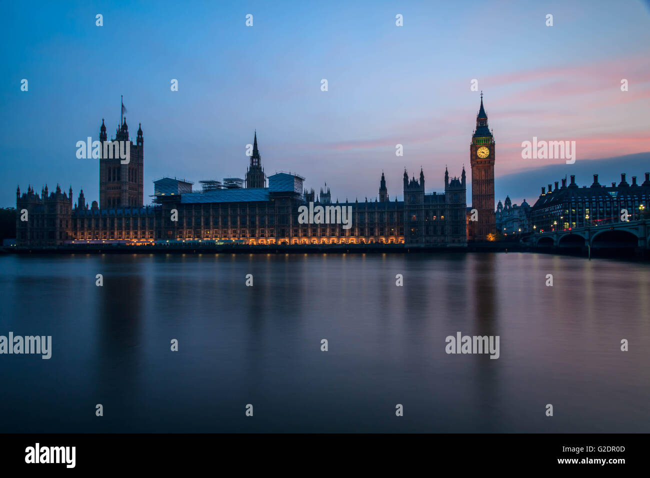 Palast von Westminster in London und dem Big Ben in der Nacht mit Fahrzeug hinterließ eine Schneise entlang der Straße, mit einem klaren blauen Himmel. Stockfoto