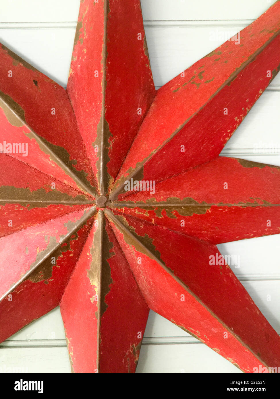 Detail eines alten Metal Star, die rot angemalt aber Farbverlust und Rost hat Mover in Stockfoto