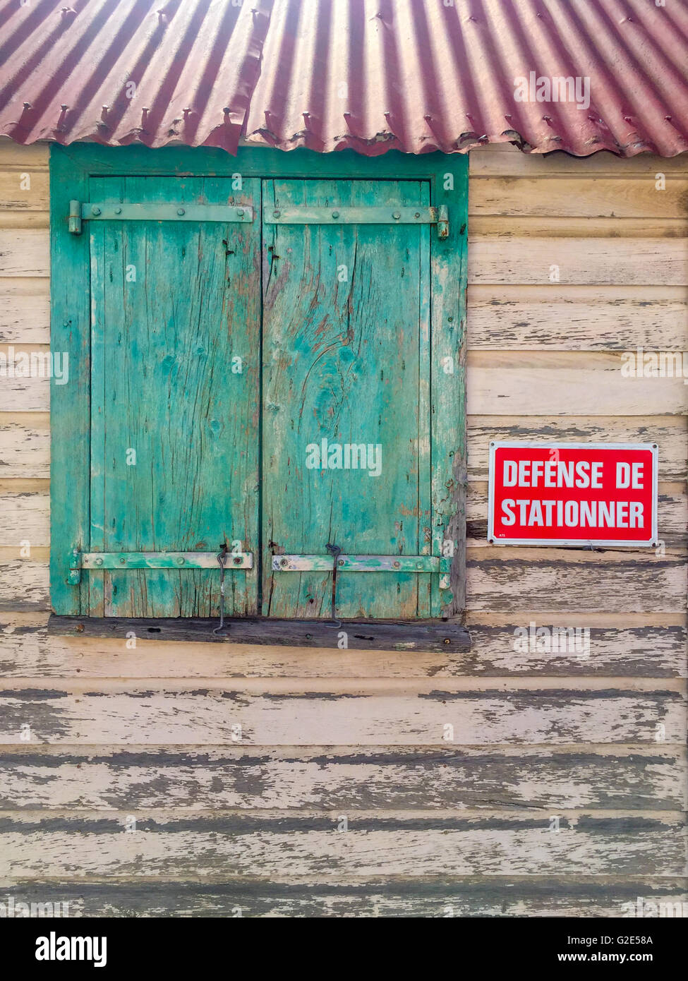 Detail des alten Gebäudes in gustavia st Bart's mit einem gewellten Blechdach und geschlossenen Fensters. Stockfoto